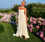 Woman in a white dress standing in a garden with pink and purple flowers and a blue sky.