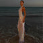 Woman in a sparkling dress standing on a beach at sunset